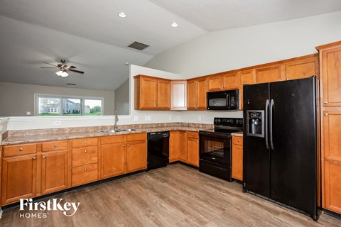 A kitchen with wooden cabinets and black appliances.