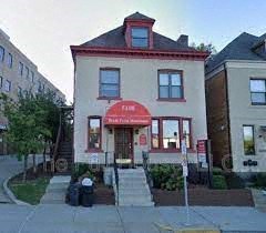 a white building with a red sign in front of it