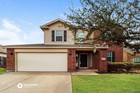 a brick house with a white garage door and a lawn