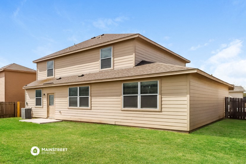the exterior of a house with a lawn and a fence