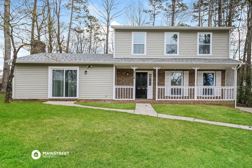 a white house with a front porch and a lawn