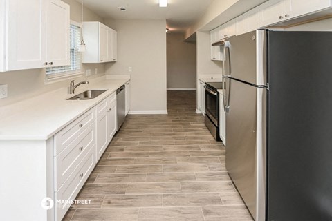 a renovated kitchen with white cabinets and stainless steel appliances
