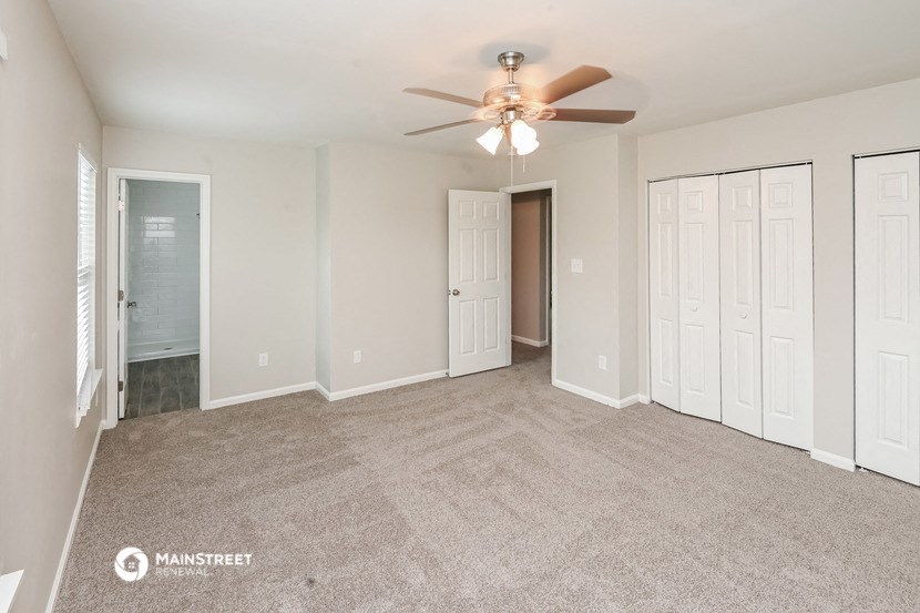 the living room of an empty home with a ceiling fan