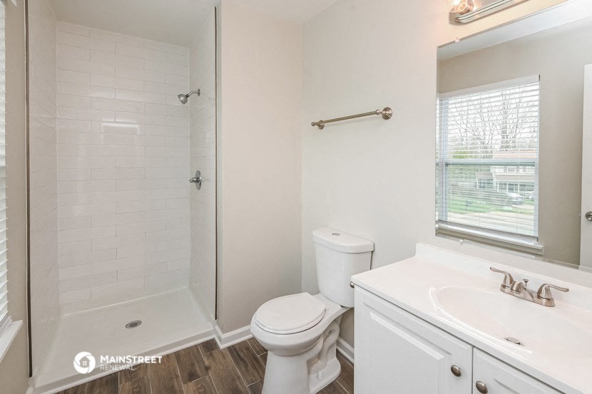 a white bathroom with a shower toilet and sink