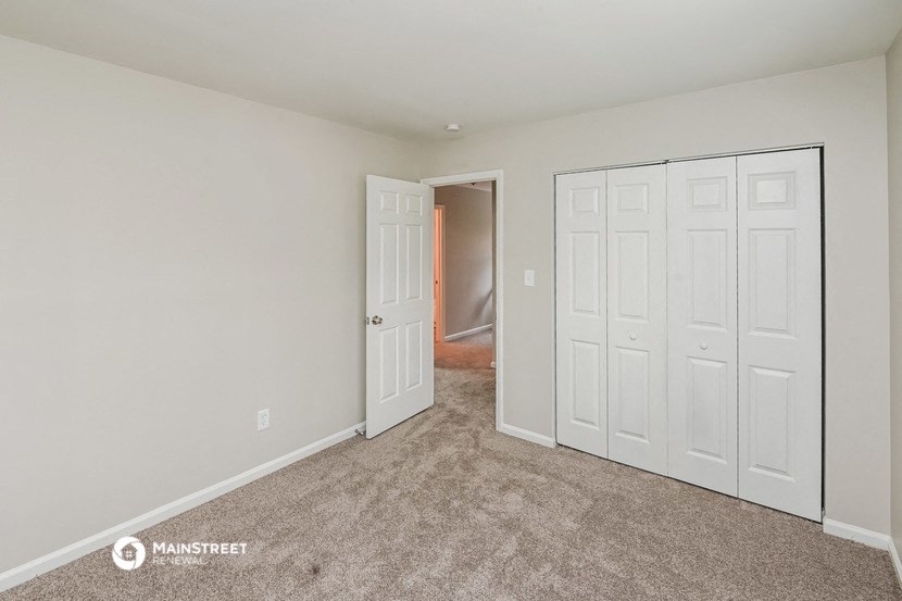 a bedroom with two closets and a door to a hallway