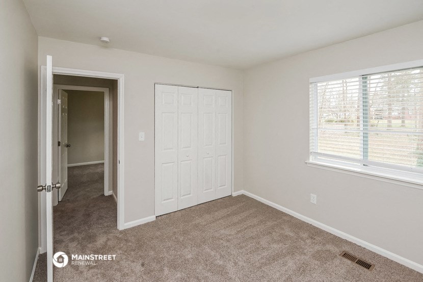 a bedroom with a closet and a door and a window