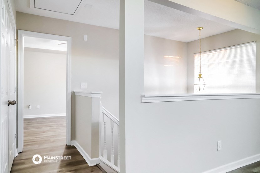 a renovated living room with white walls and wood floors