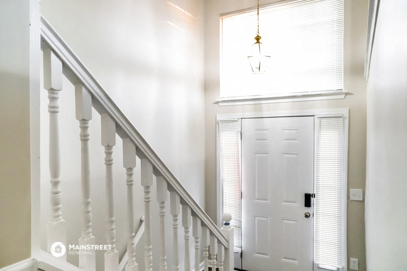 the entryway of a house with a white door and stairs