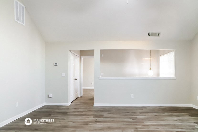 an empty living room with white walls and wood flooring