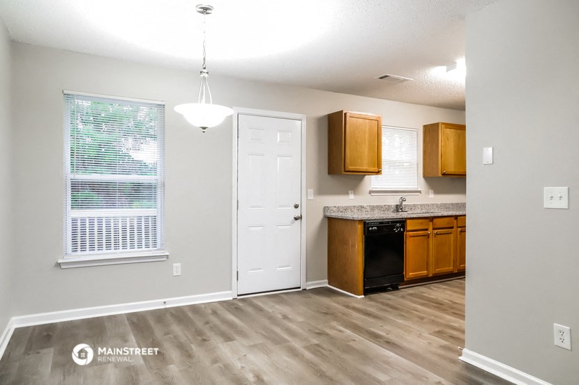 an empty kitchen with a door and a window