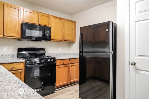 a kitchen with black appliances and wooden cabinets
