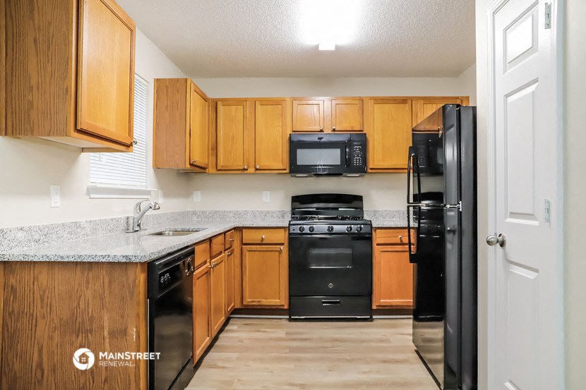 a kitchen with wooden cabinets and black appliances