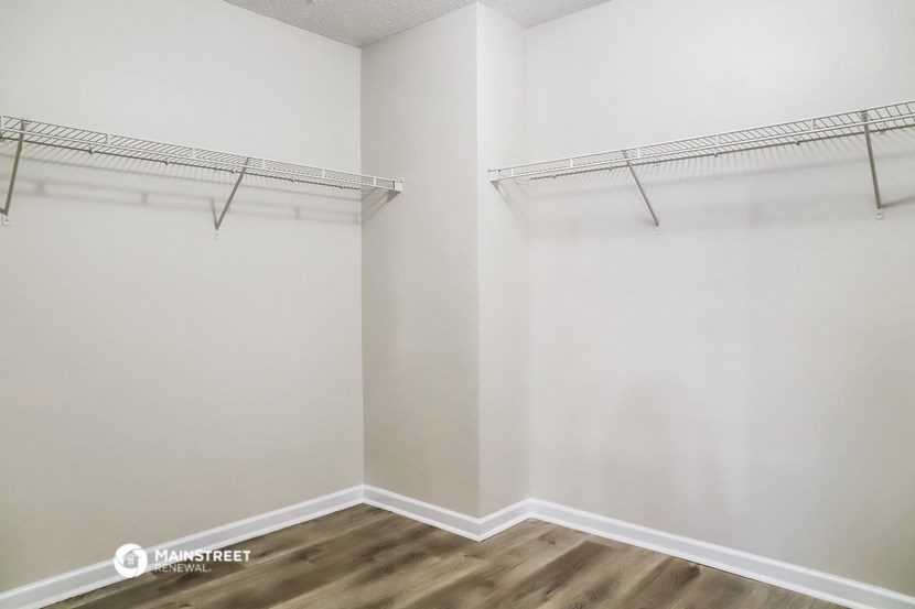 a room with white walls and an empty closet with a hanging rack