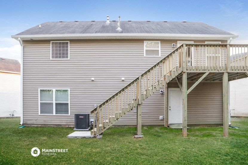 the back of a house with a staircase and a deck