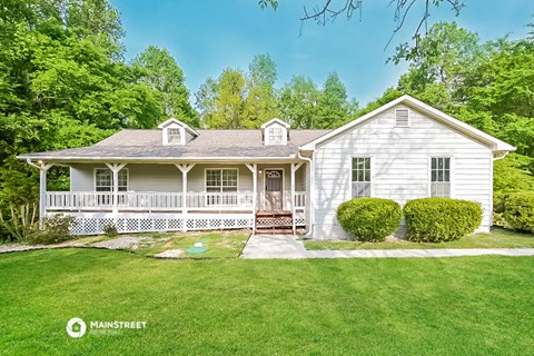 a white house with a porch and a lawn