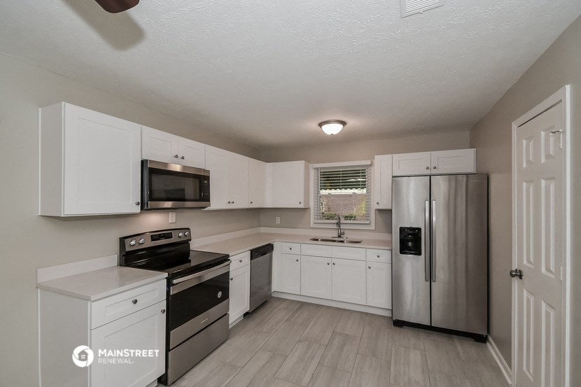 a kitchen with white cabinets and stainless steel appliances