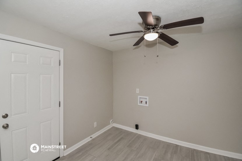 a bedroom with a ceiling fan and a door