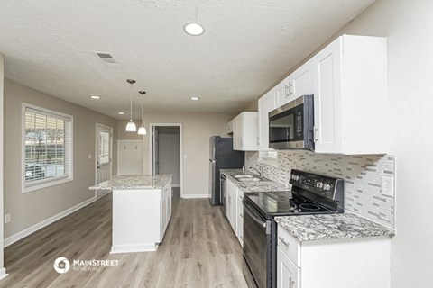 a kitchen with white cabinets and a stove and a microwave