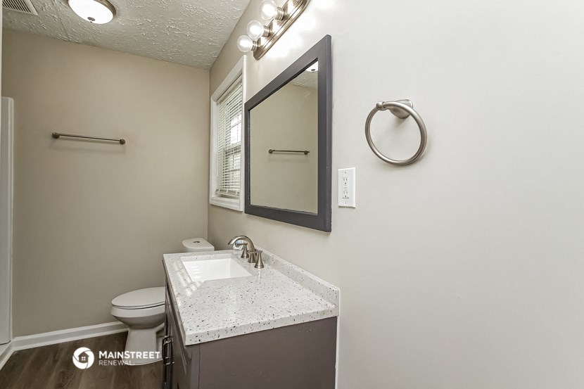 a bathroom with a sink and a mirror and a toilet