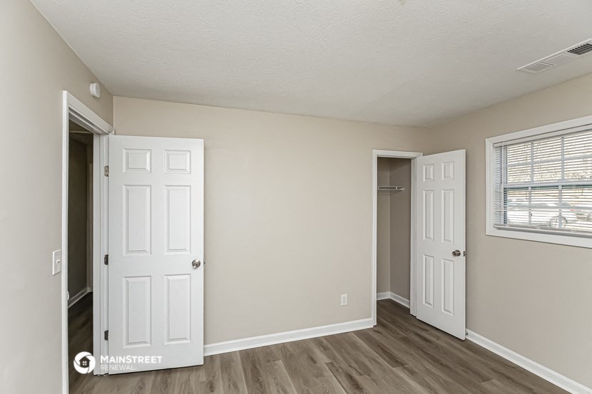 the living room of an apartment with two doors and a window