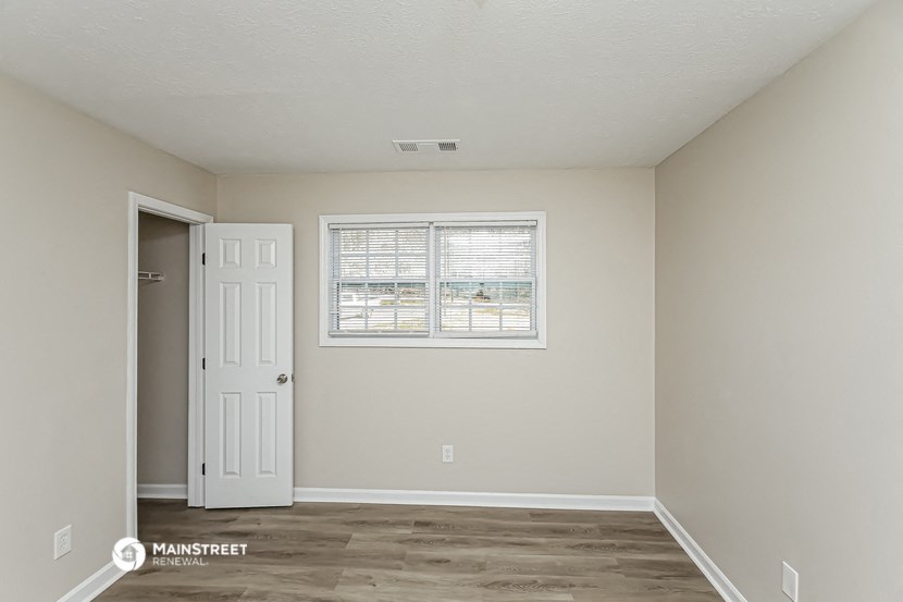 the living room of an empty house with a window and a door