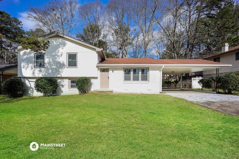 a white house with a lawn and a driveway