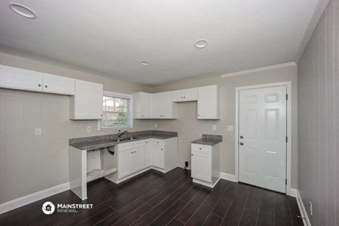 a kitchen with white cabinets and a counter top