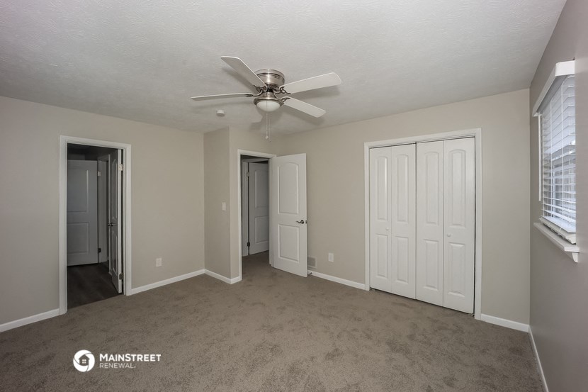 the living room of an apartment with a ceiling fan