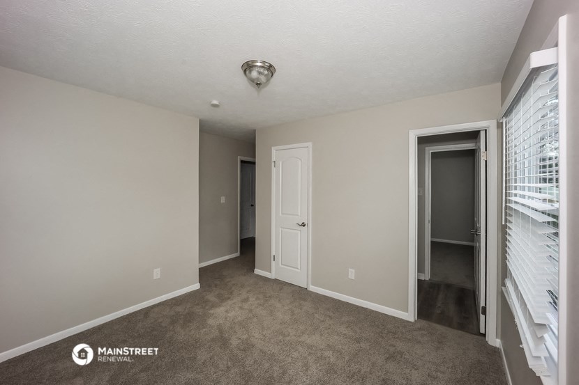 the living room of a manufactured home with a door to the hallway