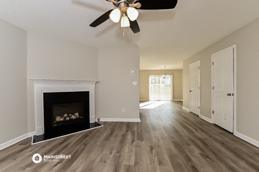 a living room with a fireplace and a ceiling fan