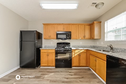 a kitchen with black appliances and wooden cabinets