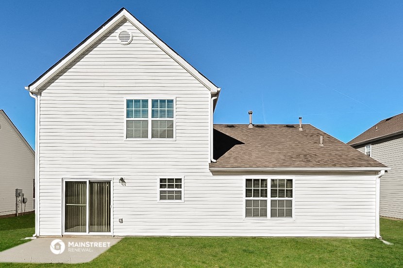 a white house with a brown roof and a blue sky