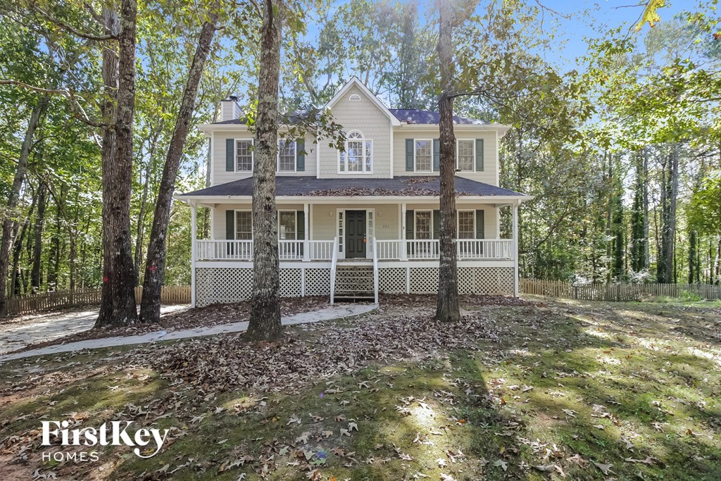 a white house in the woods with trees