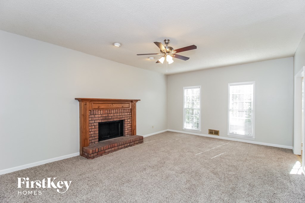 a living room with a fireplace and a ceiling fan