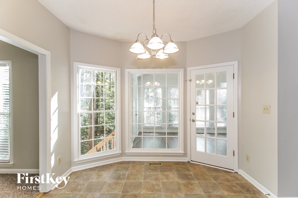 an empty dining room doors and a chandelier
