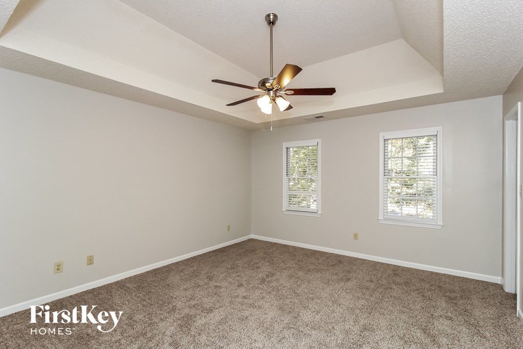 a bedroom with a ceiling fan and a carpeted floor