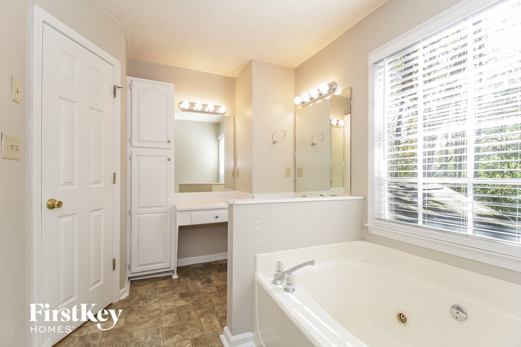a bathroom with a tub and a sink and a window