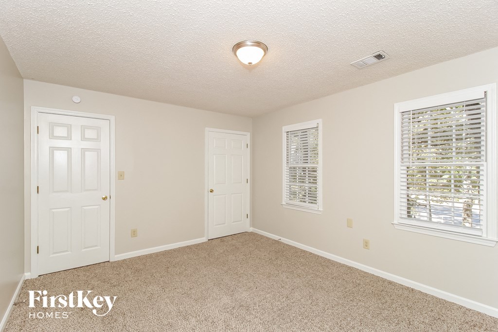a bedroom with a carpeted floor and two white doors