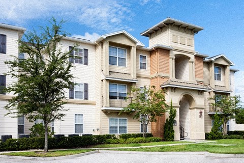 A large apartment building with a courtyard in front.