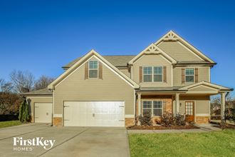 a tan house with a white garage door