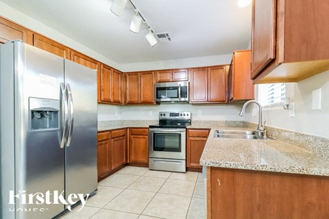 a kitchen with wooden cabinets and stainless steel appliances