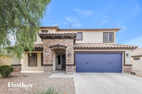 A house with a blue garage door is for sale.