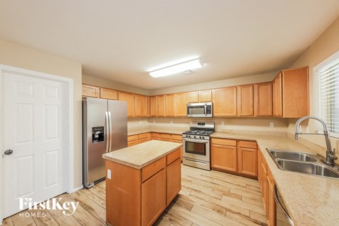 A kitchen with wooden cabinets and a stainless steel refrigerator.