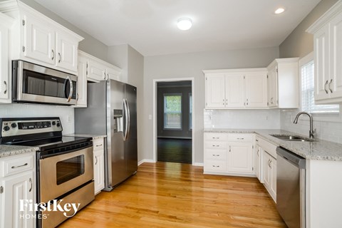 A kitchen with white cabinets and stainless steel appliances.