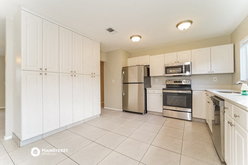 a white kitchen with stainless steel appliances and white cabinets