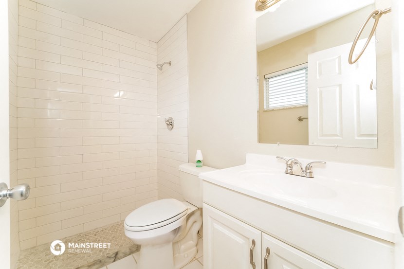 a bathroom with a toilet and a sink and a mirror