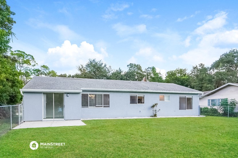 a white house with a yard and a fence