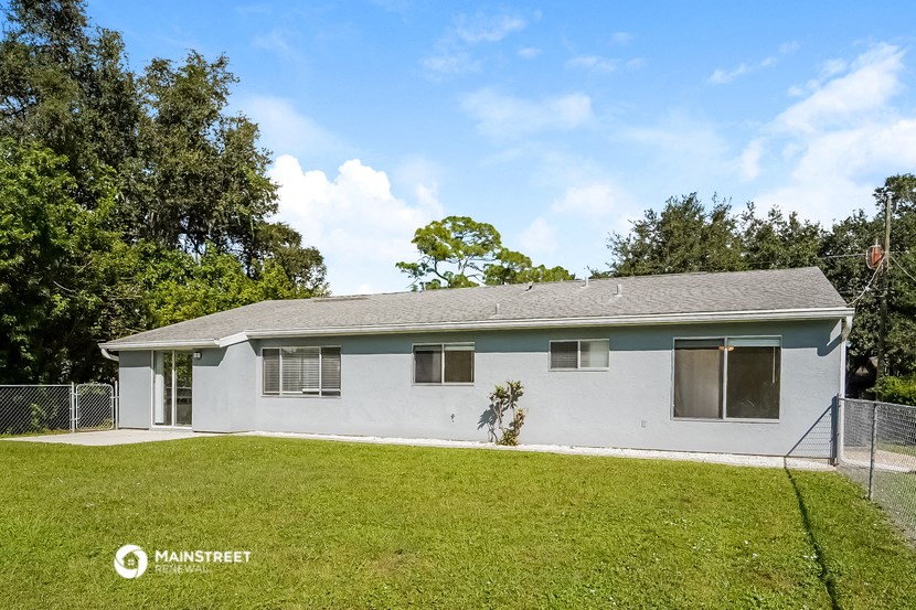a white house with a grassy yard and a fence