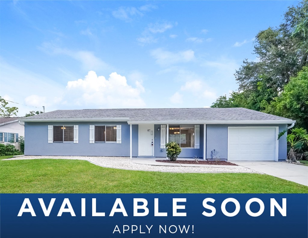 a blue house with a lawn and a white garage door