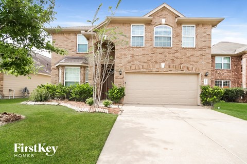 a large brick house with a driveway and a garage door